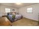 Bright bedroom featuring two windows, hardwood floors, and classic furnishings at 765 York Institute Rd, Hiddenite, NC 28636