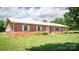 Inviting brick ranch home featuring a white metal roof, manicured lawn, and classic curb appeal at 765 York Institute Rd, Hiddenite, NC 28636