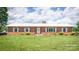 Charming brick ranch home featuring a white roof, tidy lawn, and well-maintained landscaping at 765 York Institute Rd, Hiddenite, NC 28636