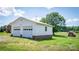 Two-car garage featuring white siding and red brick base adjacent to grassy backyard at 765 York Institute Rd, Hiddenite, NC 28636