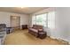 Cozy living room with neutral carpet, a large window with sheer curtains, and a comfortable seating arrangement at 765 York Institute Rd, Hiddenite, NC 28636