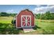 Charming red shed with white trim doors and a small wood ramp at 765 York Institute Rd, Hiddenite, NC 28636
