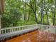 A wood deck with a built-in bench overlooking a tranquil, wooded backyard at 8 Sunrise Point Rd, Lake Wylie, SC 29710