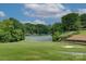 Scenic view of a golf course with a lake and lush greenery under a partly cloudy sky at 8 Sunrise Point Rd, Lake Wylie, SC 29710