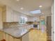 Spacious kitchen boasts white cabinets, granite countertops, and modern appliances at 8 Sunrise Point Rd, Lake Wylie, SC 29710