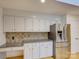 Well-lit kitchen with white cabinetry, granite countertops, and stainless steel refrigerator at 8 Sunrise Point Rd, Lake Wylie, SC 29710