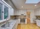 Bright kitchen features white cabinets, stainless steel appliances, and hardwood floors at 8 Sunrise Point Rd, Lake Wylie, SC 29710