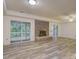 Bright living room with vinyl floors, sliding glass doors, and brick fireplace at 8 Sunrise Point Rd, Lake Wylie, SC 29710