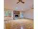 Bright living room featuring a brick fireplace, hardwood floors, and sunroom access at 8 Sunrise Point Rd, Lake Wylie, SC 29710