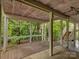 View of a screened porch with wood floors and access to a staircase; surrounded by trees at 8 Sunrise Point Rd, Lake Wylie, SC 29710
