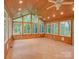 Cozy sunroom with tile floors, wood paneled walls and ceiling, and many windows at 8 Sunrise Point Rd, Lake Wylie, SC 29710
