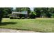 Quaint house with lush lawn, covered porch, and mature trees for a relaxing setting at 8000 Chapman St, Charlotte, NC 28216