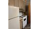 Modest kitchen with an older stove, fridge, and simple cabinets, offering room for updates at 8000 Chapman St, Charlotte, NC 28216