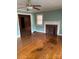 Inviting living room with hardwood floors, a ceiling fan, and a classic brick fireplace at 8000 Chapman St, Charlotte, NC 28216