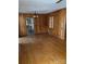 Living room featuring wood paneling, hardwood floors, and an open doorway to the kitchen at 8000 Chapman St, Charlotte, NC 28216