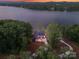 Aerial view of home nestled among lush trees, offering privacy and serene lake views, showcasing its secluded location at 8066 Edgewater Dr # 103, Norwood, NC 28128
