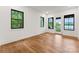 A bright bedroom features hardwood floors, natural light, and a private balcony with scenic lake views at 8066 Edgewater Dr # 103, Norwood, NC 28128