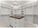 A custom walk-in closet boasts ample shelving, hanging rods, and a center island for organization at 8066 Edgewater Dr # 103, Norwood, NC 28128