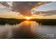 Scenic lake view with a vibrant sunset, highlighting the property's prime waterfront location and tranquil setting at 8066 Edgewater Dr # 103, Norwood, NC 28128