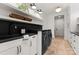 A modern laundry room includes black countertops, white cabinets, and sleek appliances for convenience at 8066 Edgewater Dr # 103, Norwood, NC 28128