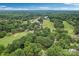 Aerial view showcasing a lush community with extensive green spaces and a golf course at 8117 Rising Meadow Rd, Charlotte, NC 28277