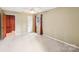 Neutral bedroom features a ceiling fan, large window, and a doorway leading to another room at 8117 Rising Meadow Rd, Charlotte, NC 28277