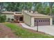 Attractive exterior of a home with a two-car garage, surrounded by mature trees and greenery at 8117 Rising Meadow Rd, Charlotte, NC 28277