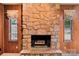 Close up of a stone fireplace with decorative windows and wood paneling at 8117 Rising Meadow Rd, Charlotte, NC 28277