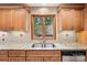 Close up of kitchen counter with stainless sink under wooden-framed window at 8117 Rising Meadow Rd, Charlotte, NC 28277