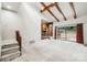 Bright living room features exposed ceiling beams, stone fireplace, and sliding doors to the outdoor patio at 8117 Rising Meadow Rd, Charlotte, NC 28277