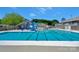 Large community pool with a slide, surrounded by green trees and buildings offers recreational fun at 8117 Rising Meadow Rd, Charlotte, NC 28277