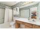 Well-lit bathroom featuring a vanity, decorative wallpaper, and a shower-tub combination at 9006 Four Mile Creek Rd, Charlotte, NC 28277