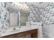 Cozy bathroom featuring floral wallpaper, well-lit mirror, and a functional sink and shower at 9006 Four Mile Creek Rd, Charlotte, NC 28277