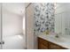 Bright bathroom featuring floral wallpaper, a well-lit mirror, and a view into the bedroom at 9006 Four Mile Creek Rd, Charlotte, NC 28277