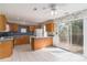 Well-lit kitchen features wood cabinetry, tile flooring, breakfast bar, and sliding doors to outdoor deck at 9006 Four Mile Creek Rd, Charlotte, NC 28277