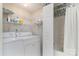 Practical laundry area equipped with a washer, dryer, wire shelving, and access to a shower area at 9006 Four Mile Creek Rd, Charlotte, NC 28277