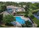 Community pool with lounge chairs near multi-colored townhomes and a pond, surrounded by lush landscaping and mature trees at 9006 Four Mile Creek Rd, Charlotte, NC 28277