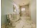 Clean bathroom featuring a toilet, vanity, tub, and shower with marble tile at 102 Lake Dr, Hickory, NC 28601