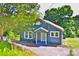 Charming blue home featuring a quaint entryway and surrounded by lush greenery and shade trees at 102 Lake Dr, Hickory, NC 28601