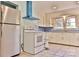 Cozy kitchen with white appliances, white cabinets, and light-blue walls and accents at 102 Lake Dr, Hickory, NC 28601