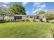 Expansive backyard featuring a well-maintained lawn and a white-brick home with screened porch and a patio area at 1041 Brawley School Rd, Mooresville, NC 28117