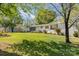 Well-manicured lawn surrounds this single story brick home with a screened-in porch on a sunny day at 1041 Brawley School Rd, Mooresville, NC 28117