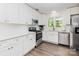Modern kitchen features white cabinets, stainless steel appliances, and hardwood flooring at 1041 Brawley School Rd, Mooresville, NC 28117