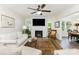 Cozy living room features a ceiling fan, brick fireplace, and ample natural light at 1041 Brawley School Rd, Mooresville, NC 28117