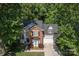 Aerial view of a two-story home with brick and siding, lush landscaping, and a paved driveway at 10419 Chelsea Bay Dr, Charlotte, NC 28278