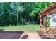 Private backyard with a lush lawn, mature trees, a brick patio, and a pergola with a swing at 10419 Chelsea Bay Dr, Charlotte, NC 28278