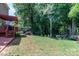 View of the expansive backyard and patio featuring a lush lawn, mature trees, and beautiful landscaping at 10419 Chelsea Bay Dr, Charlotte, NC 28278