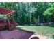 Expansive backyard features a lush lawn, mature trees, and a brick patio with stairs to the deck at 10419 Chelsea Bay Dr, Charlotte, NC 28278
