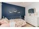 Bedroom featuring a white dresser and navy accent wall with floral decorations at 10419 Chelsea Bay Dr, Charlotte, NC 28278