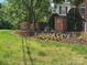 Landscaped community entrance with a brick sign and wrought iron details that reads, 